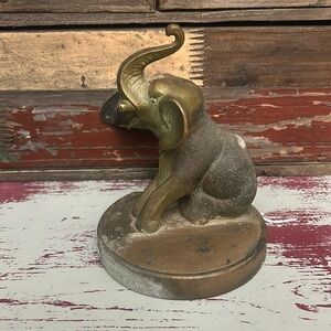 Brass elephant statue that has a brass base as well.